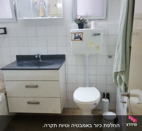 חדר אמבטיה עם כיור, אסלה ואריחים לבנים